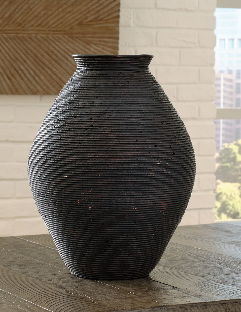 Dark textured ceramic vase with ribbed horizontal lines and rounded body