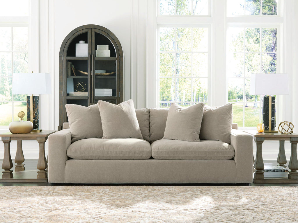 Light gray fabric sofa with five back pillows and boxy arms, low seat