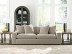 Light gray fabric sofa with five back pillows and boxy arms, low seat