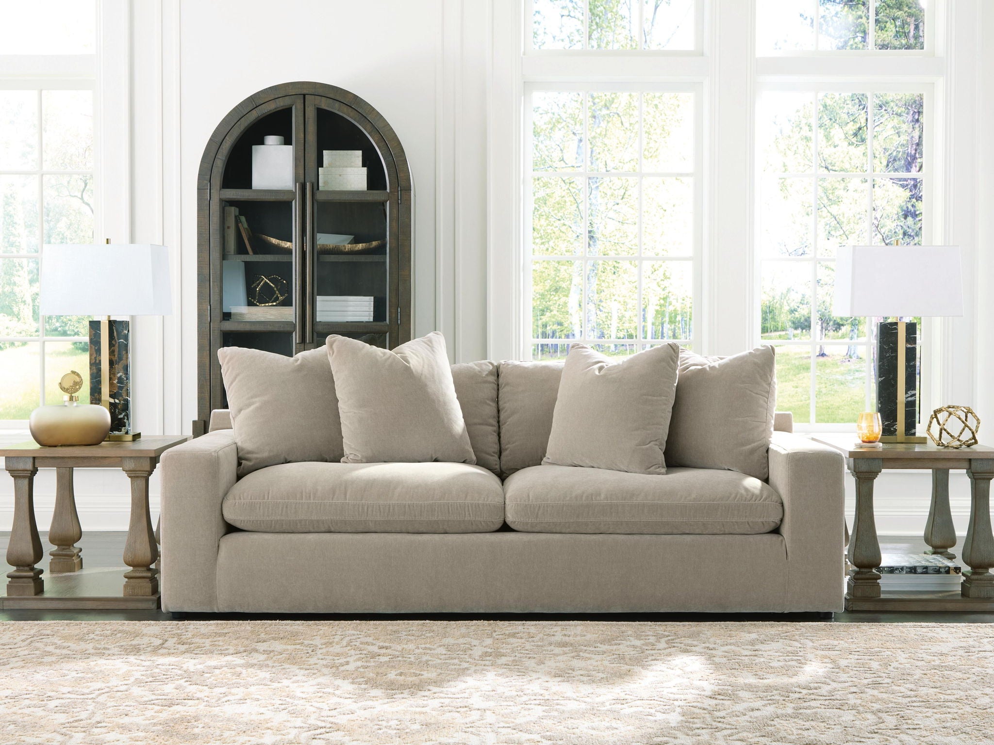 Light gray fabric sofa with five back pillows and boxy arms, low seat