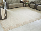 Beige living room rug with geometric border detail along the edge