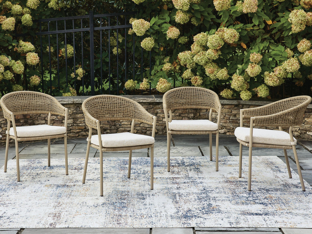 Set of 4 beige woven arm chairs with upholstered seat cushions, side-by-side view.