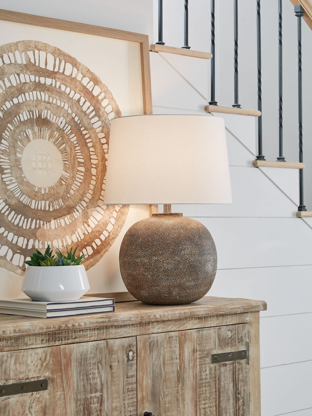 Antique brown metal table lamp with white fabric shade and textured globe base