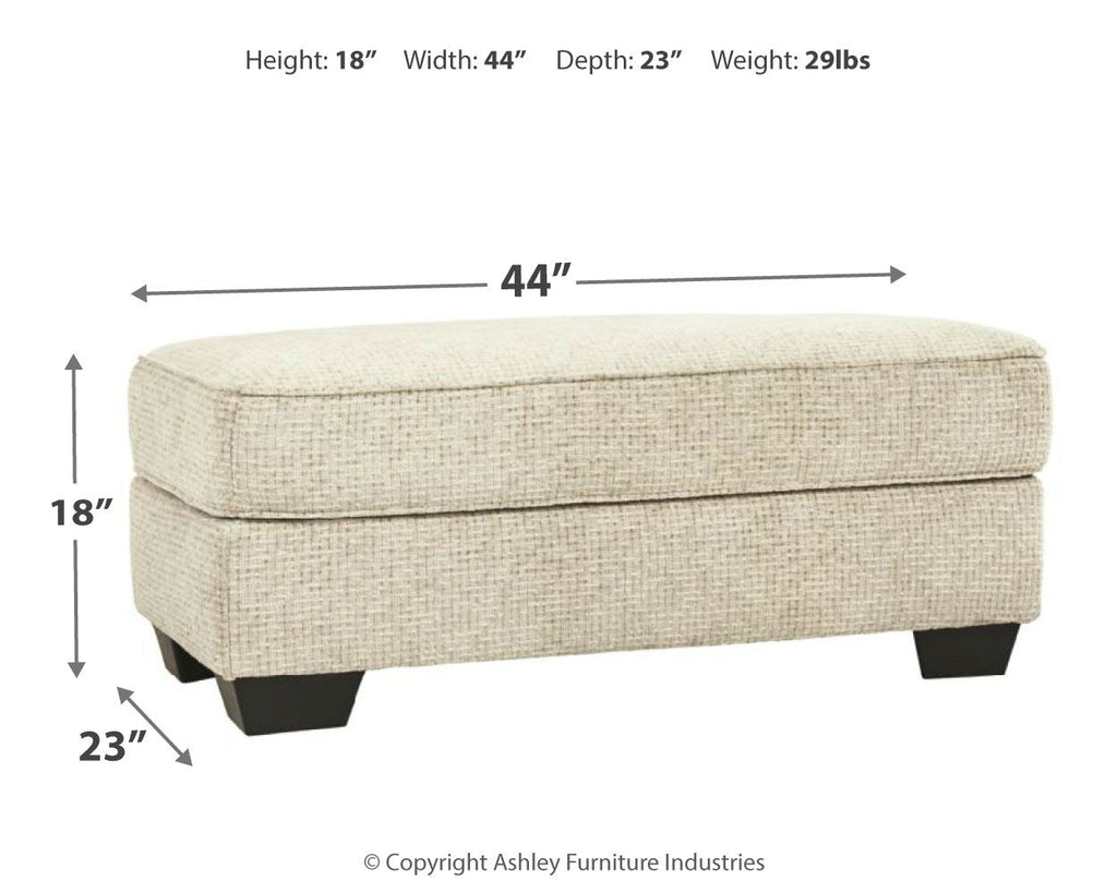 Sandstone ottoman, 44in wide, 23in deep, 18in high; cushioned top, dark legs