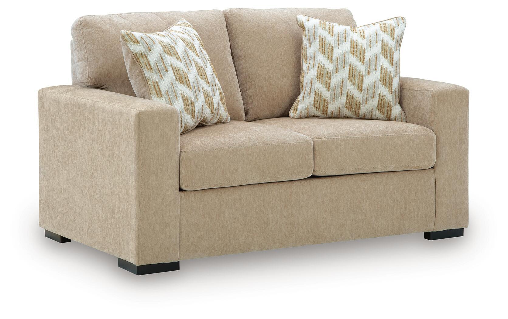 Light beige upholstered loveseat with two geometric throw pillows