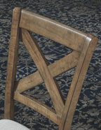 Upholstered dining chair back with dark wood frame and X-cross brace.