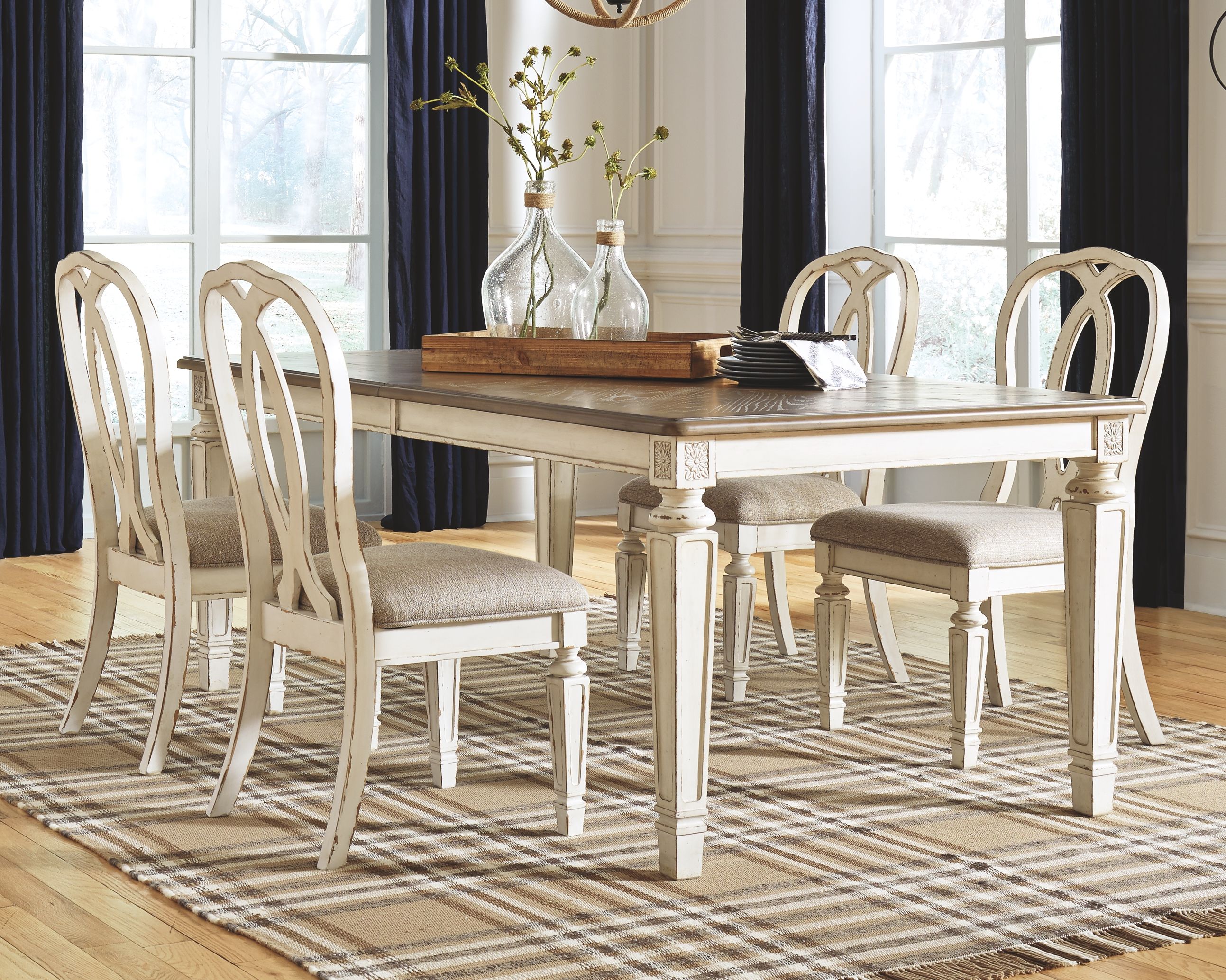 Dining extension table with chipped white legs and dark wood surface in dining setup