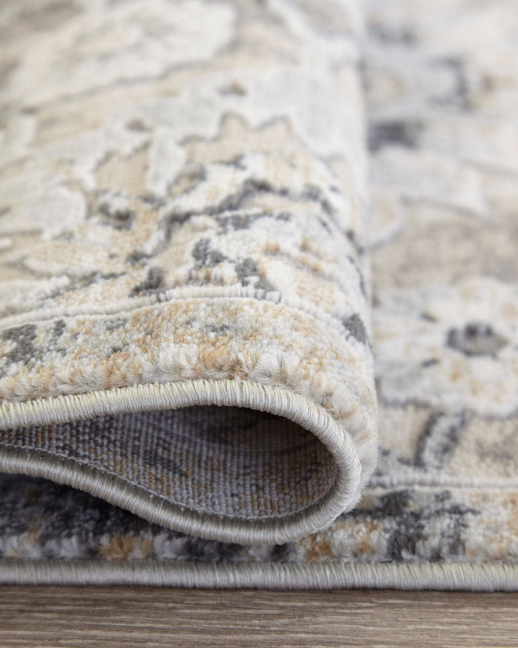 Gray and cream area rug border with stitched rolled edge