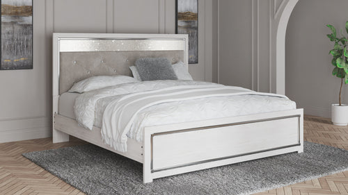 King bed with white frame and beige upholstered headboard, diamond-tufted