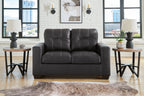 Black loveseat with tufted back, two-seat cushions, and padded armrests