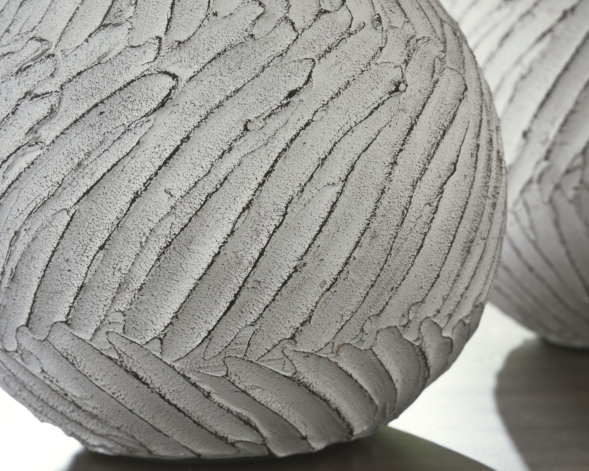 White vase bottom and curved base with textured vertical stripes