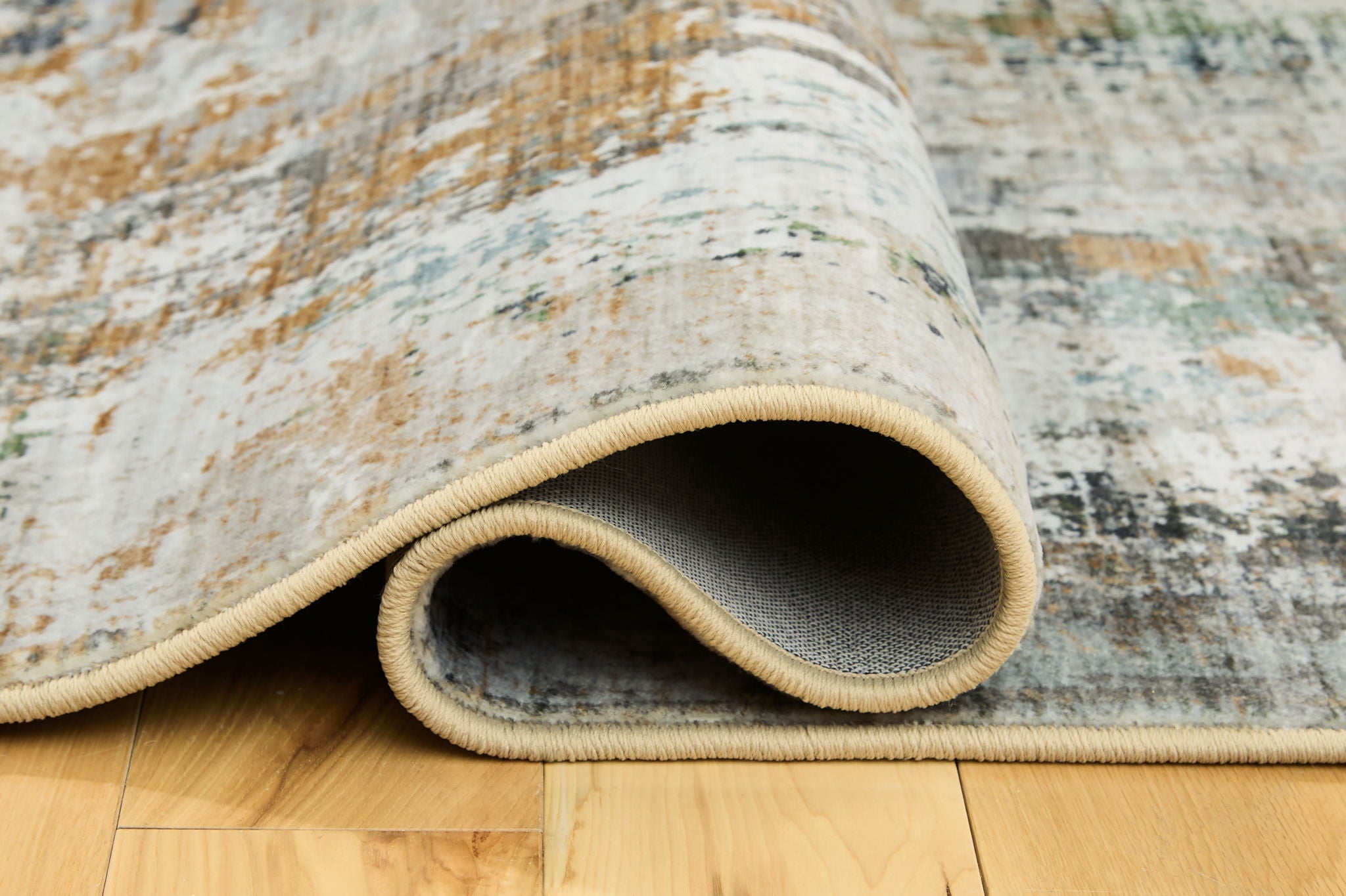 Abstract area rug rolled edge, light cream and muted blue-gray distressed pattern
