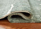 Light blue area rug showing thick low-pile texture and rolled edge