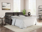 Dark gray sofa sleeper with pull-out mattress and two patterned throw pillows