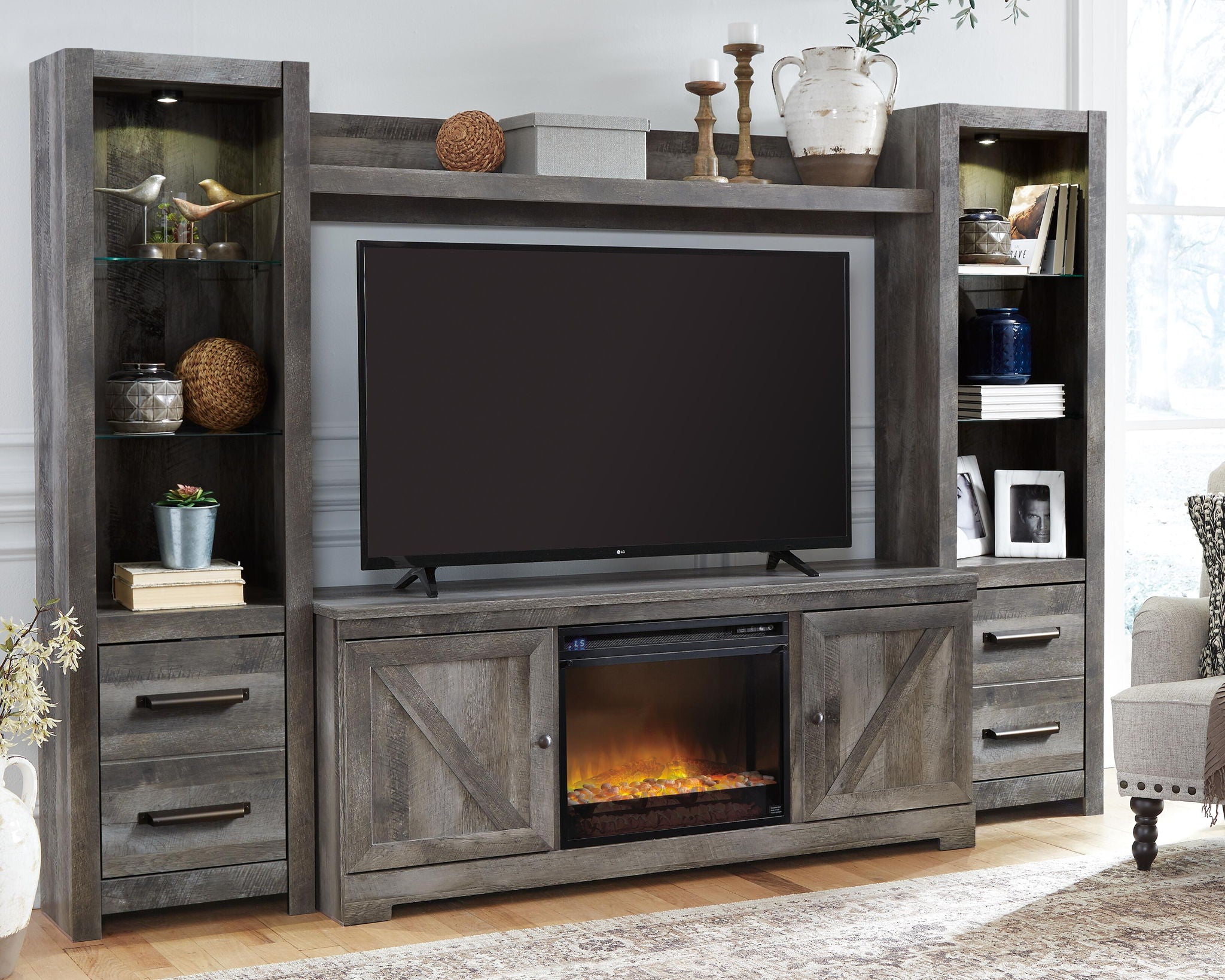Gray entertainment center with TV opening, storage drawers, and lit faux fireplace insert