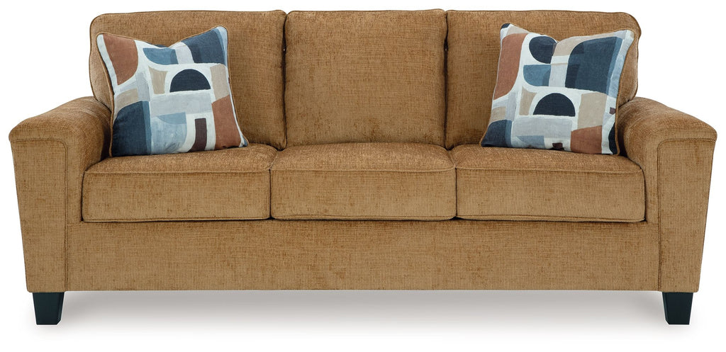 Beige sofa with three seat cushions and two patterned throw pillows