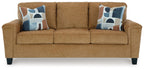 Beige sofa with three seat cushions and two patterned throw pillows