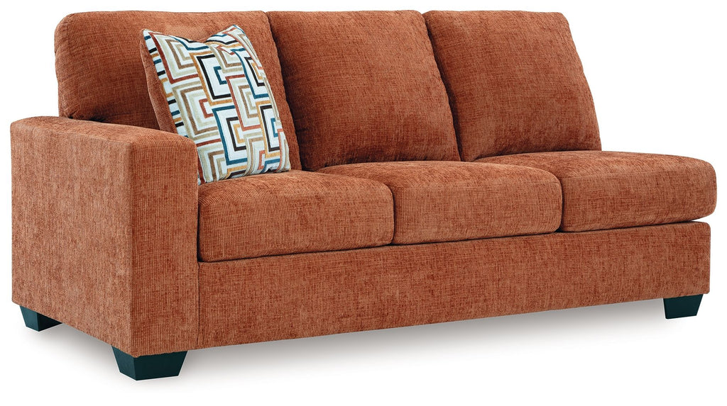 Brown fabric sofa with three seat cushions and patterned accent throw pillow