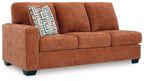 Brown fabric sofa with three seat cushions and patterned accent throw pillow