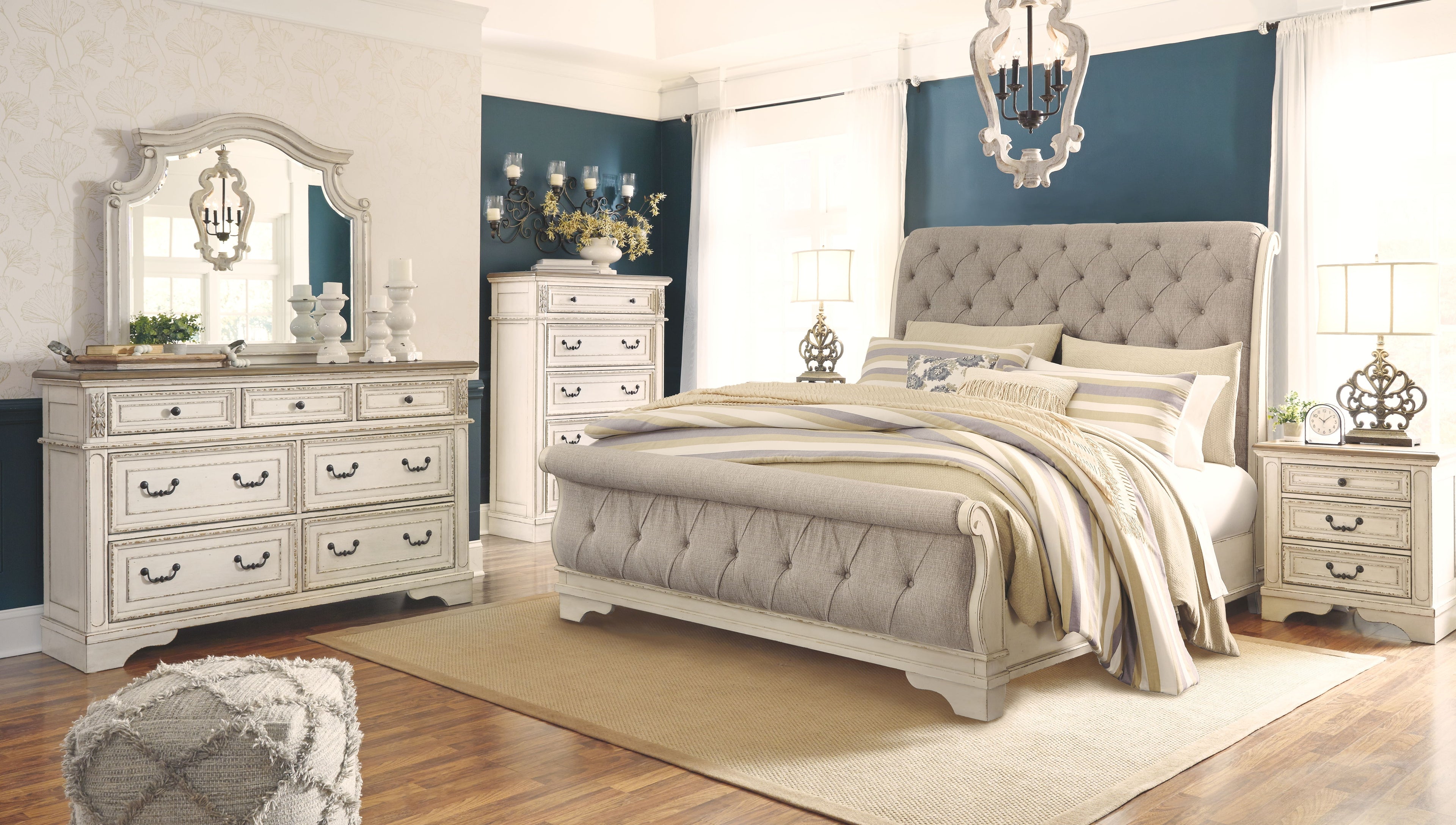 White sleigh bed with tufted headboard and footboard, dressed with striped bedding