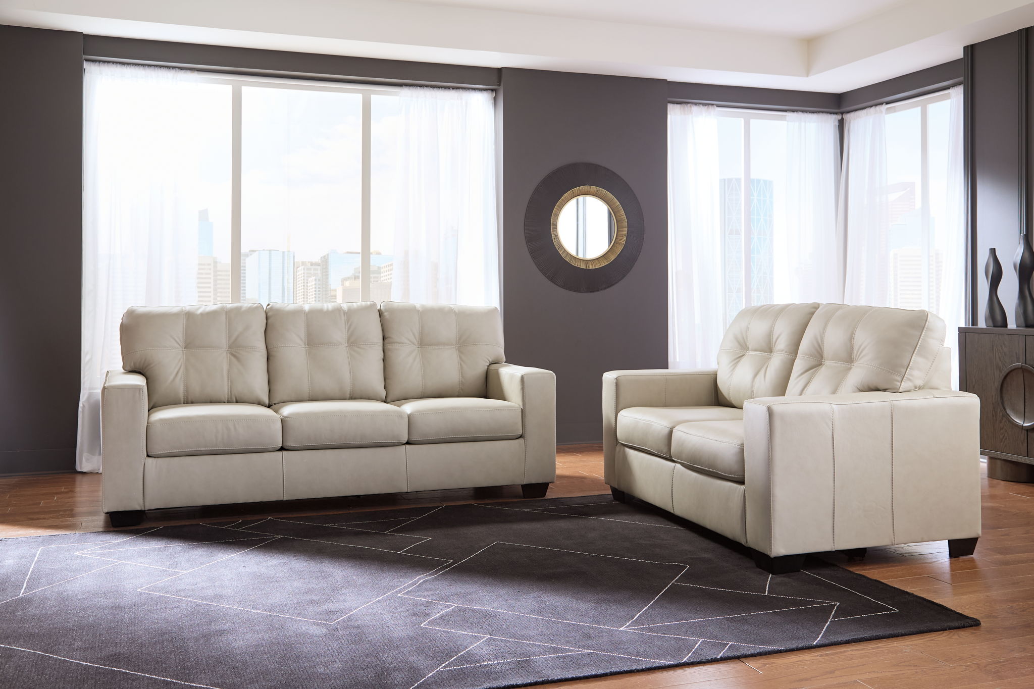 Beige upholstered sofa and loveseat set with tufted backs, wide room view