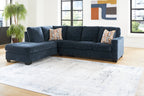 Dark navy sectional sofa with corner chaise and patterned accent pillows