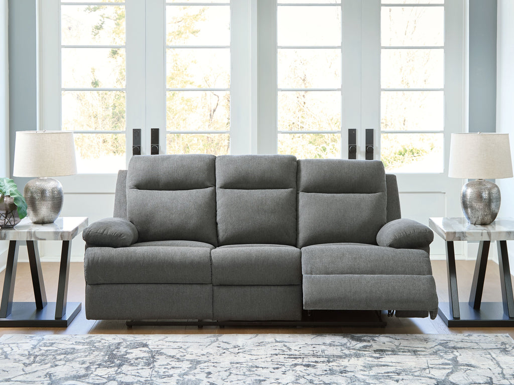 Dark gray reclining sofa in textured fabric with rounded armrests and chaise-style seat