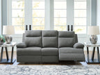 Dark gray reclining sofa in textured fabric with rounded armrests and chaise-style seat