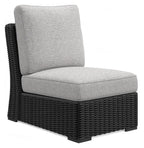 Light gray armless chair with cushion on black woven wicker base