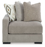 Pebble gray corner chair with tall backrest and textured fabric throw pillows