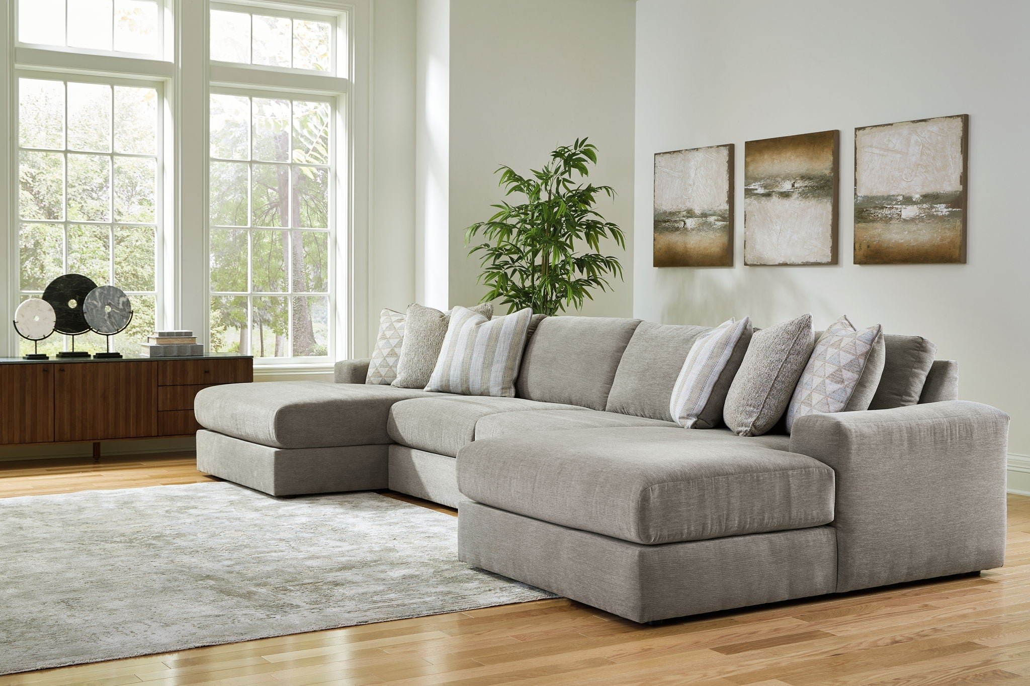 Gray sectional sofa with chaise-style corner and layered neutral accent pillows