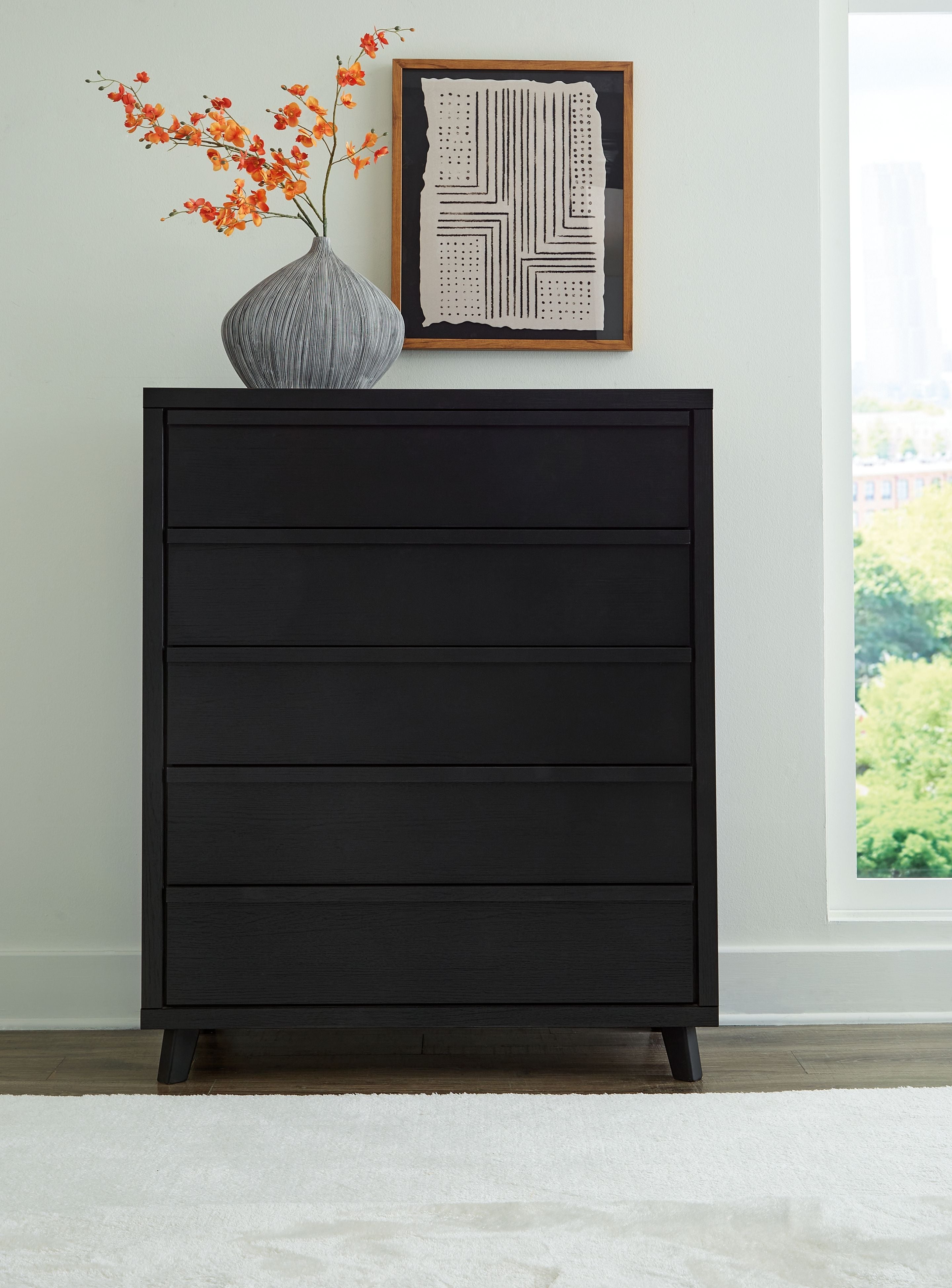 Black wide chest with multiple drawer fronts and dark wooden legs