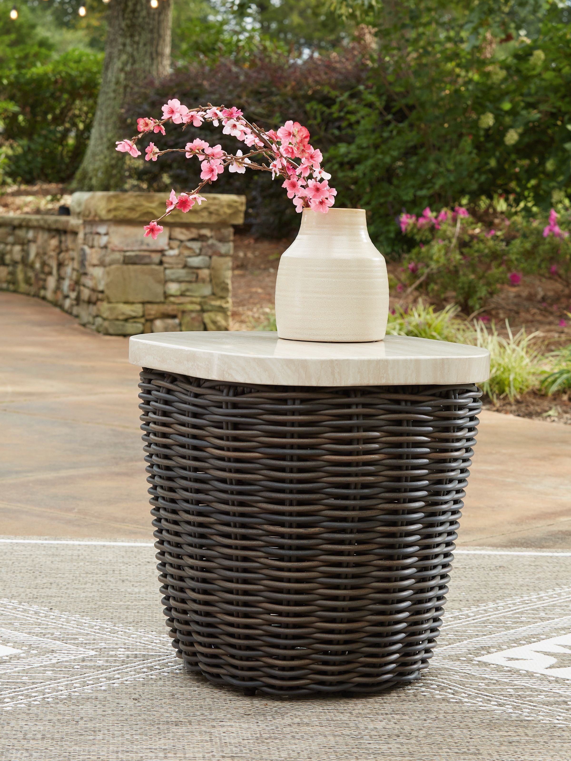 Dark brown wicker side table with round beige top and woven sides