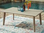 Beige rectangular dining table with drinks on tabletop and four tapered legs