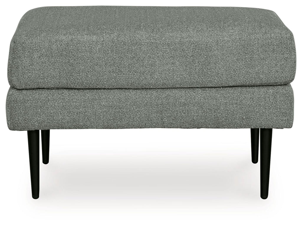 Charcoal upholstered ottoman with visible seam line and tapered black legs