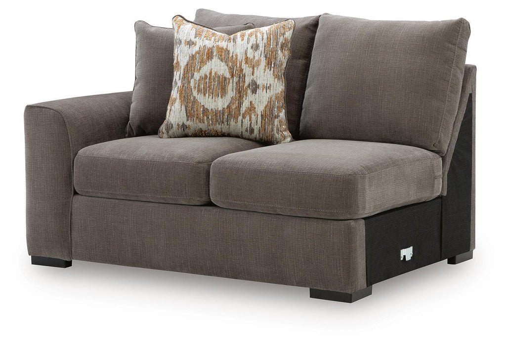 Dark gray upholstered loveseat with back cushions and patterned accent pillow
