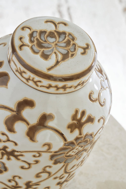 Adalham ceramic jar lid with cream surface and brown floral medallion pattern.