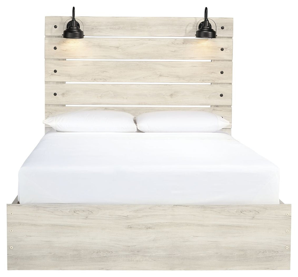 Light wood panel bed with two front drawers; white bedding and two black lamps on headboard