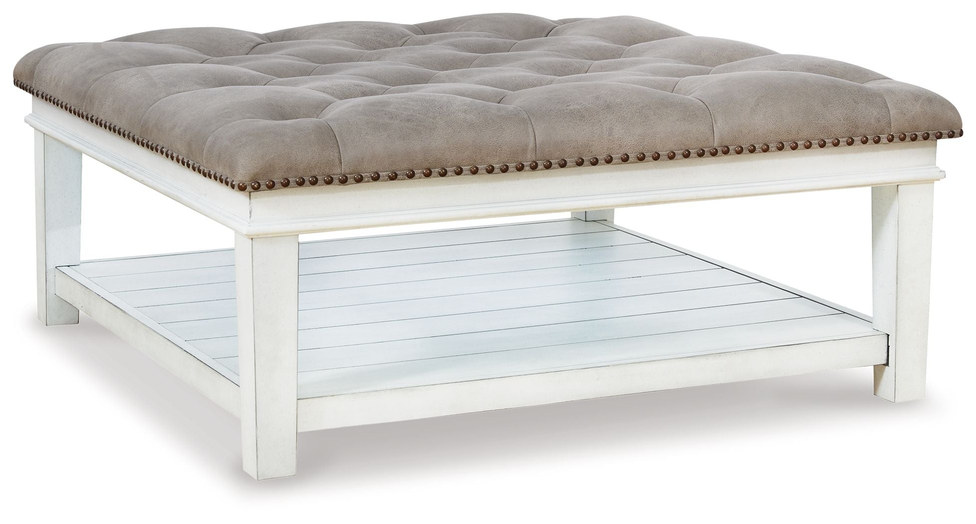 Tufted ottoman cocktail table in light beige, whitewash legs, nailhead trim, shelf