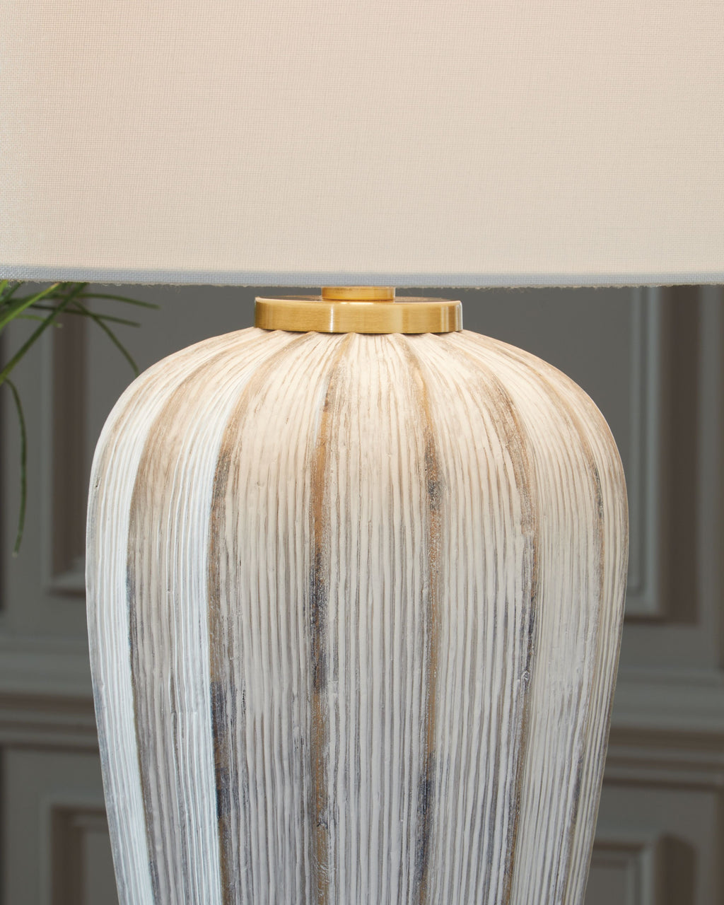 Striped poly table lamp base with brass-toned top cap and white drum shade
