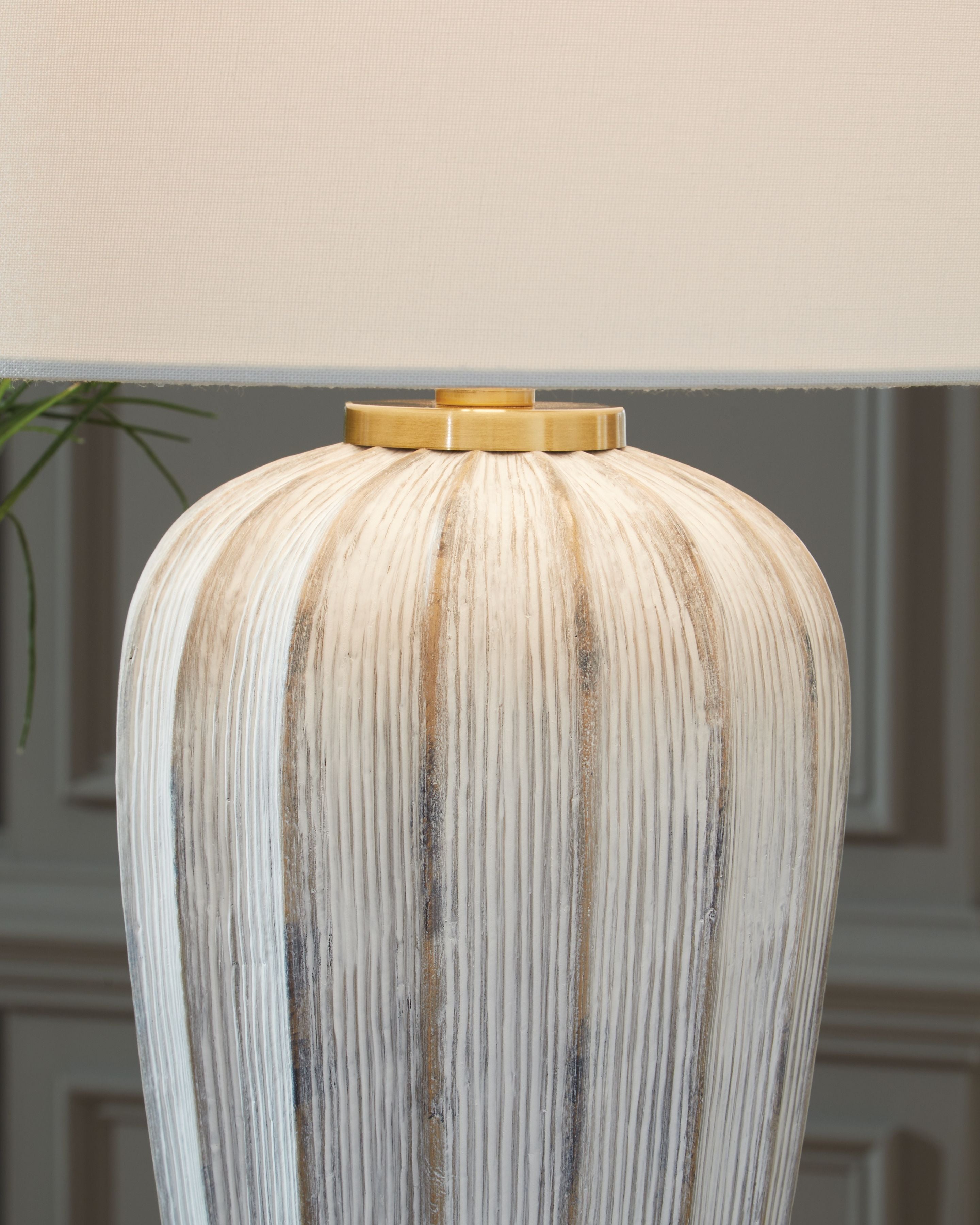 Striped poly table lamp base with brass-toned top cap and white drum shade