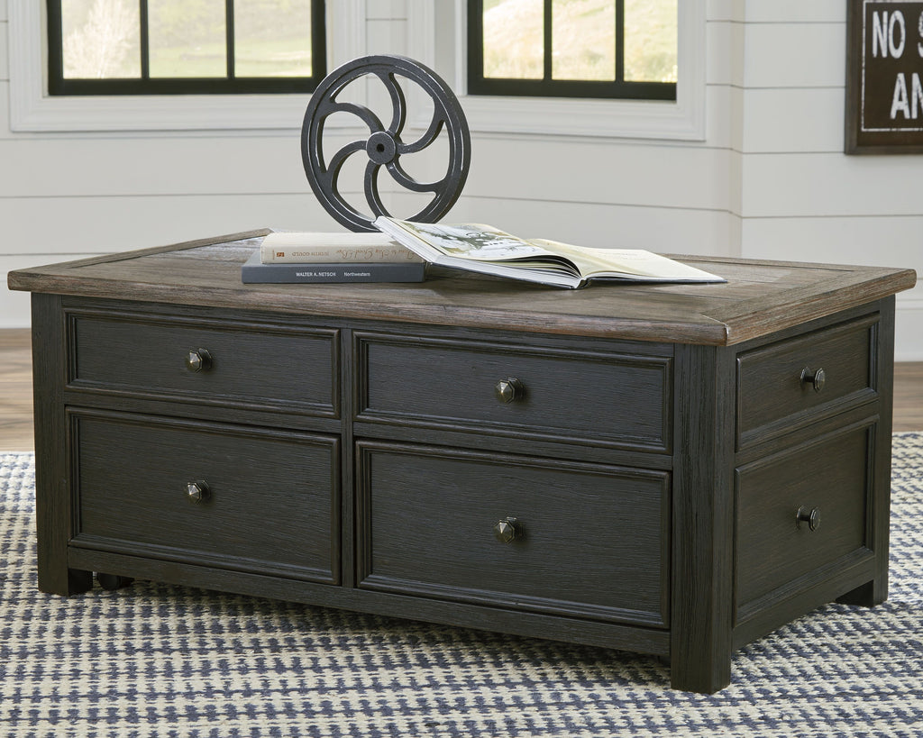 Dark gray lift-top cocktail table with four drawers and hinged top, brass knobs visible.