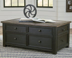 Dark gray lift-top cocktail table with four drawers and hinged top, brass knobs visible.