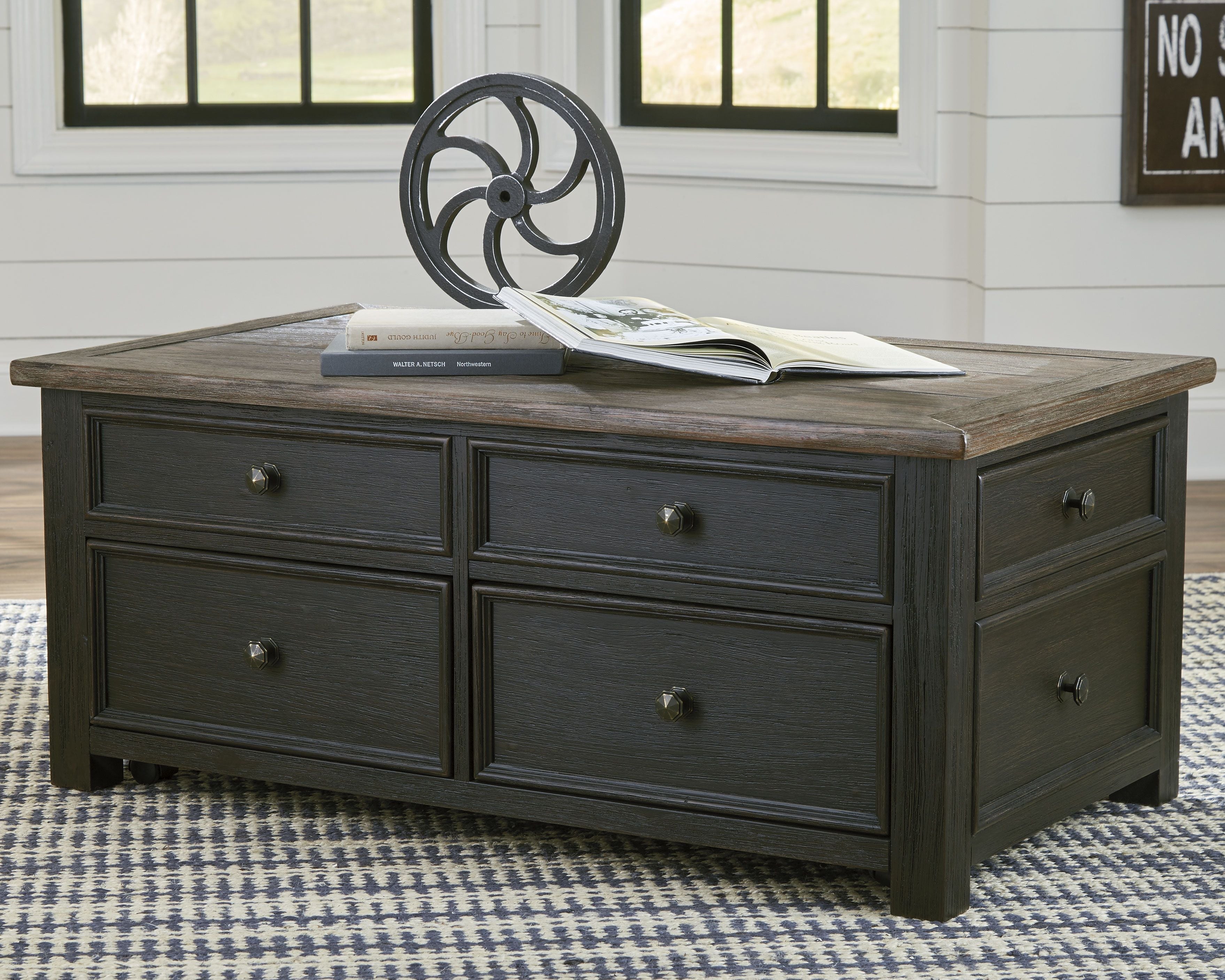 Dark gray lift-top cocktail table with four drawers and hinged top, brass knobs visible.