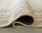 Beige rug corner with rolled underside and stitched geometric details