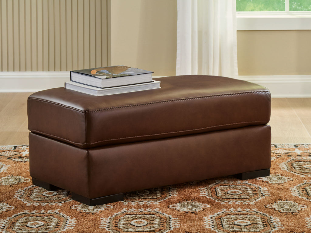 Brown leather ottoman with cushioned top and sturdy square legs