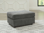 Dark gray fabric ottoman with a square padded top and low block base.