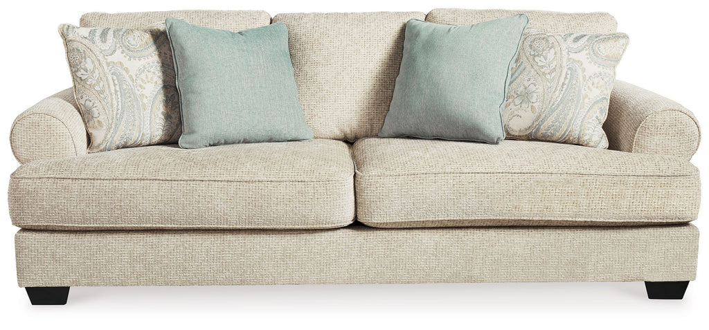 Beige fabric sofa with two seat cushions and blue accent pillows, wide arms and legs