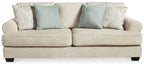 Beige fabric sofa with two seat cushions and blue accent pillows, wide arms and legs