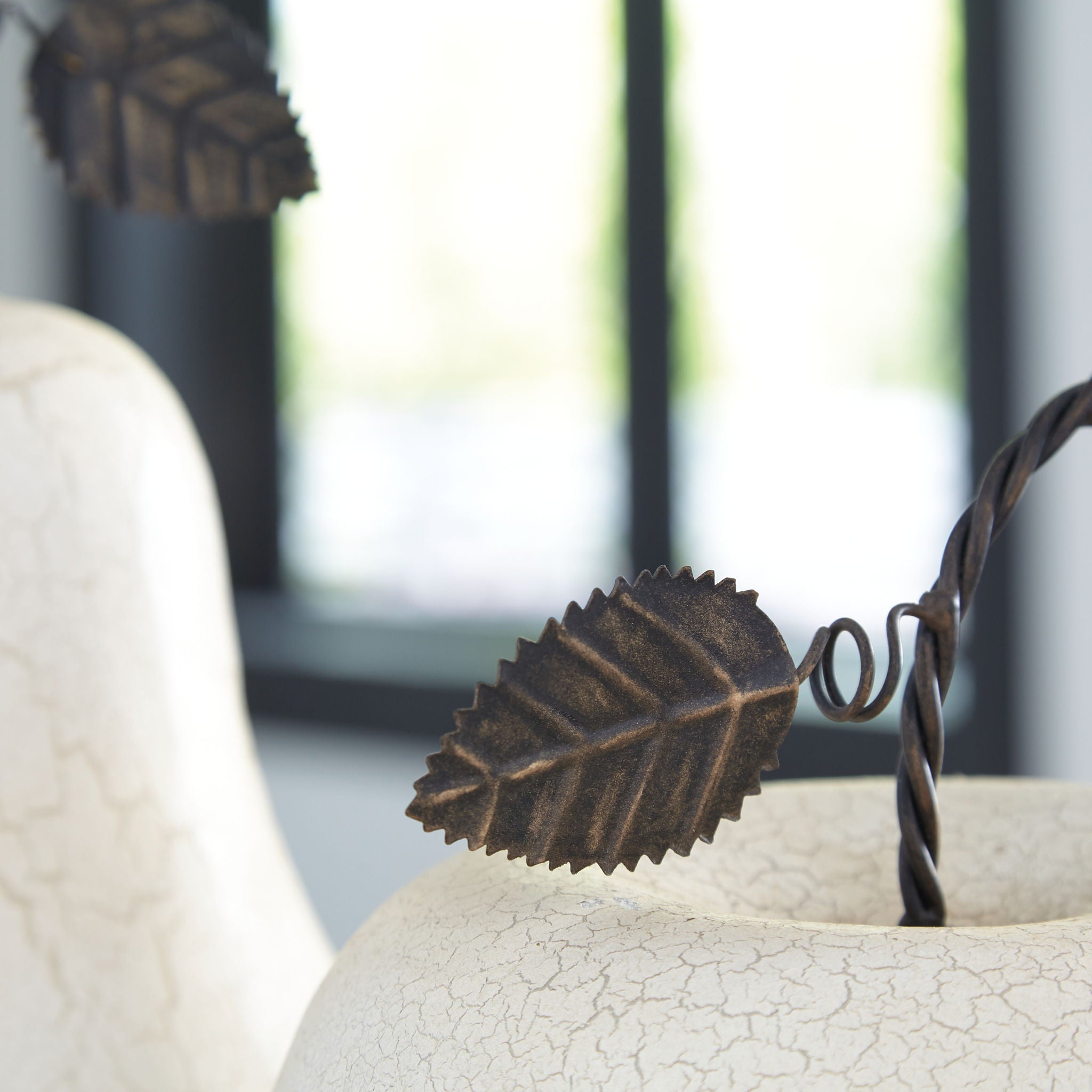 Antique white crackle pear sculpture with black leaf-and-cord top detail